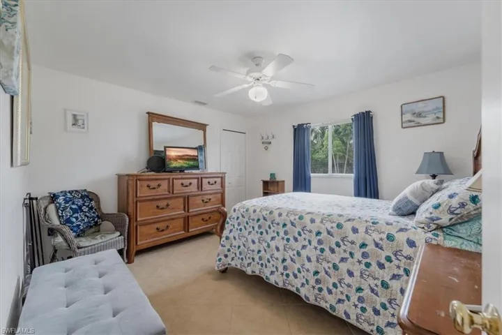Bedroom with light tile patterned floors, a closet, and a ceiling fan