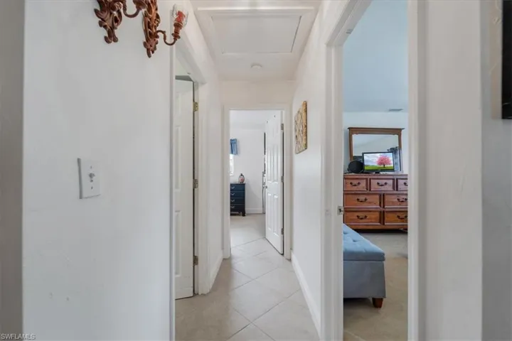Corridor with light tile patterned floors and baseboards