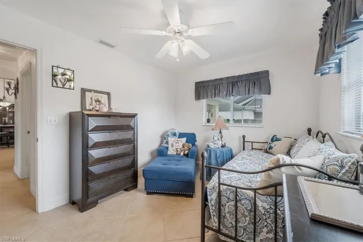 Bedroom with light tile patterned floors and ceiling fan