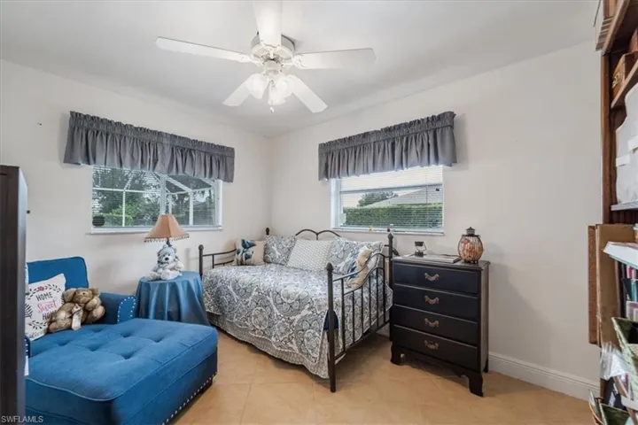 Bedroom with light tile patterned floors and ceiling fan