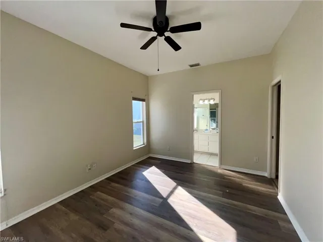 Unfurnished room featuring dark wood finished floors and a ceiling fan