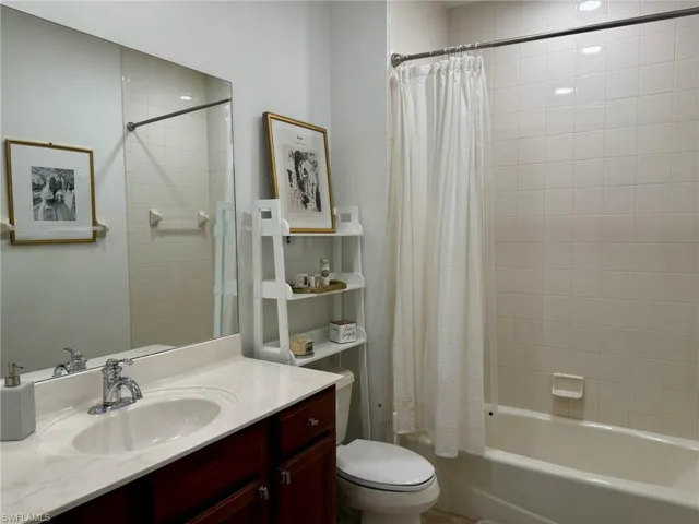Bathroom with shower / bath combination with curtain and vanity