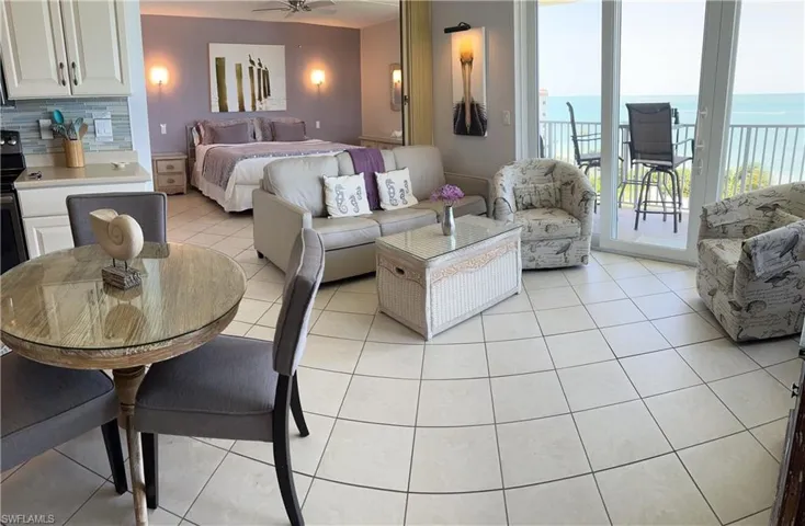 Bedroom featuring access to exterior, light tile patterned floors, and a water view