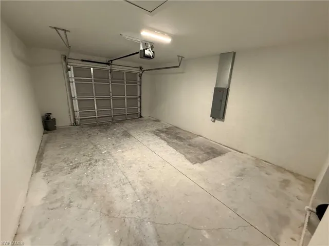 Garage with electric panel and a garage door opener