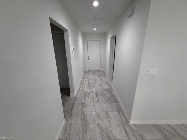 Hall with baseboards and recessed lighting