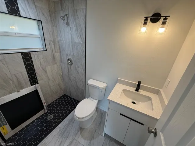 Bathroom featuring vanity and tiled shower