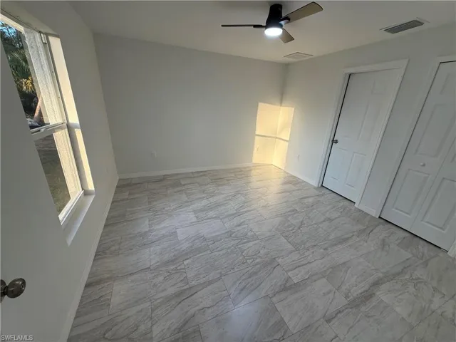 Unfurnished bedroom featuring baseboards and ceiling fan