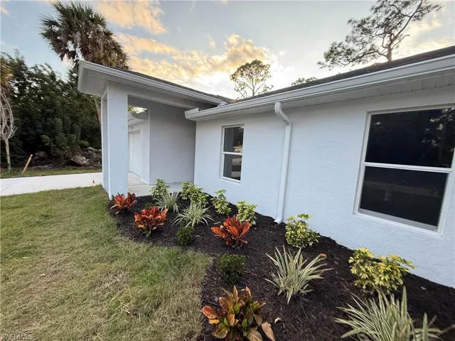 View of side of property with stucco siding and a lawn