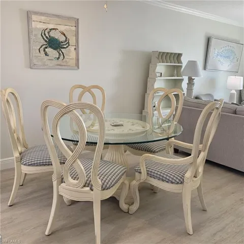Dining area with light wood finished floors and ornamental molding