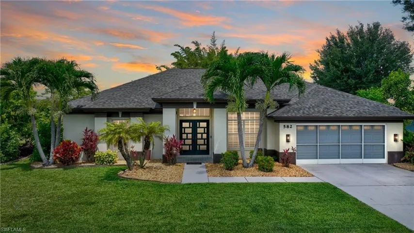 Twilight View of front of house with a garage that includes a screen for that area