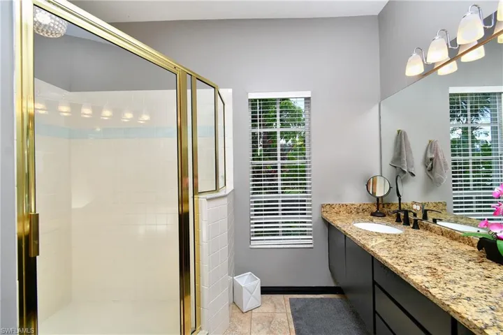 Bathroom featuring an enclosed shower, oversized vanity, and tile floors