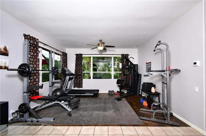 Family room/Exercise area featuring dark wood-like flooring and ceiling fan
