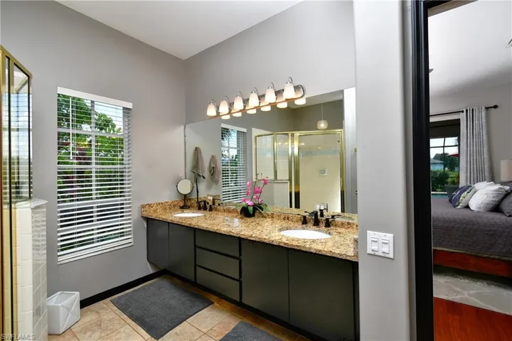 Bathroom with a shower, tile flooring, double sink, and oversized vanity