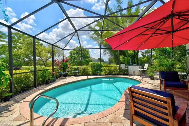 View of pool with seating area and screened lanai