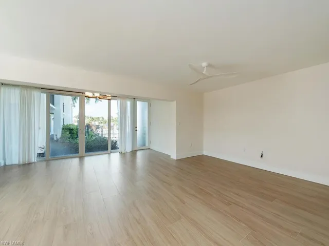 Unfurnished living room to front entry and sliders toward Community Pool