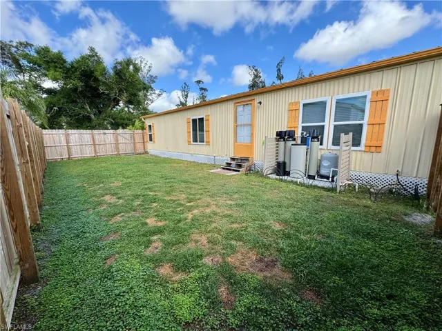 View of yard with a fenced backyard and entry steps