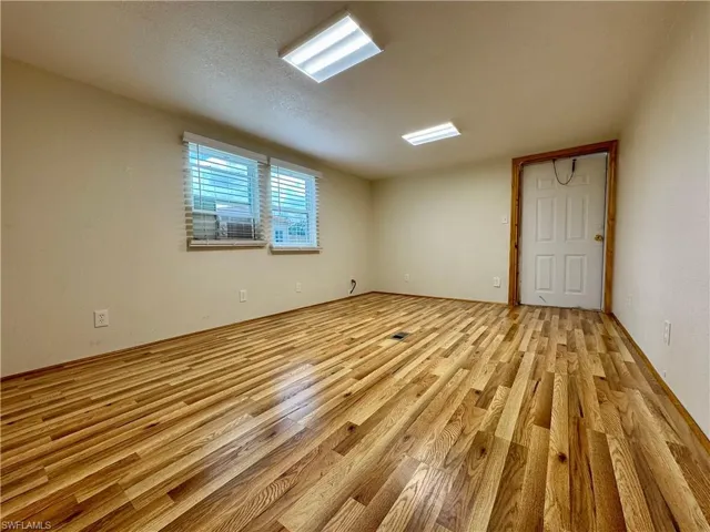 Unfurnished room with light wood-type flooring and a textured ceiling