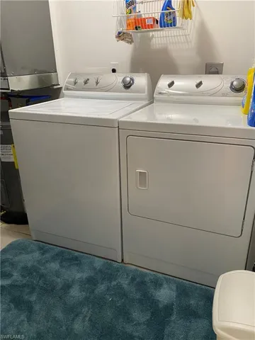 Laundry room featuring separate washer and dryer and dark colored carpet