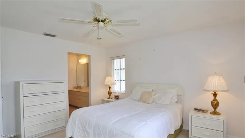Bedroom featuring ceiling fan and ensuite bathroom