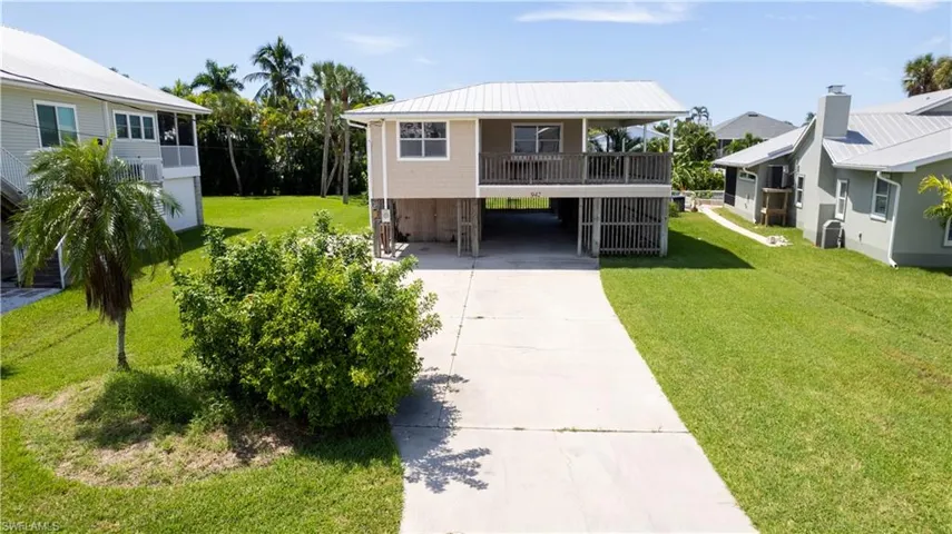 View of front of home featuring a carport and a front lawn