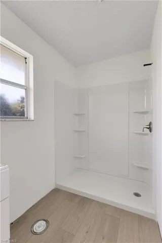 Bathroom with a shower, hardwood / wood-style floors, and a textured ceiling