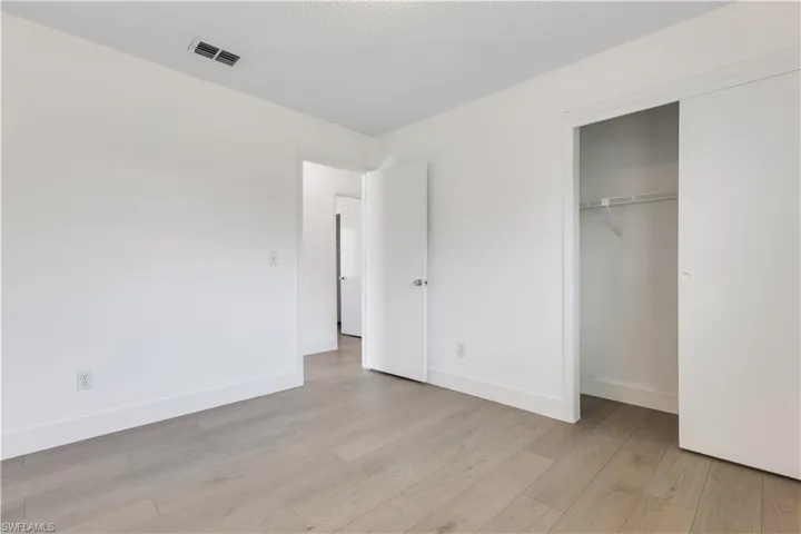 Unfurnished bedroom with a closet and light hardwood / wood-style floors