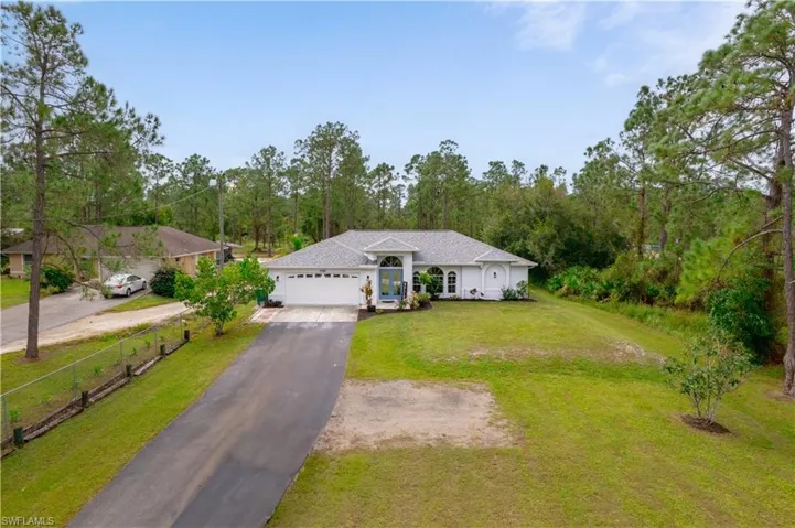 Ranch-style home featuring a front lawn and a garage