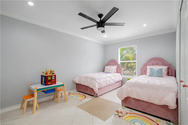 Tiled bedroom featuring crown molding and ceiling fan