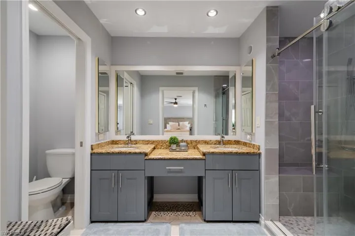 Bathroom with vanity, toilet, and an enclosed shower
