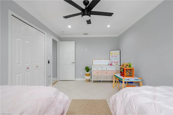 Bedroom with a closet, ceiling fan, and crown molding
