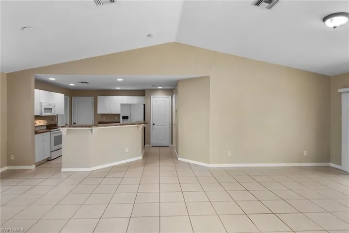 Unfurnished living room featuring lofted ceiling and recessed lighting