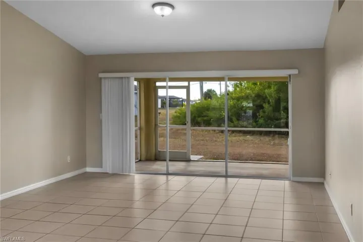 Empty room with baseboards and light tile patterned flooring