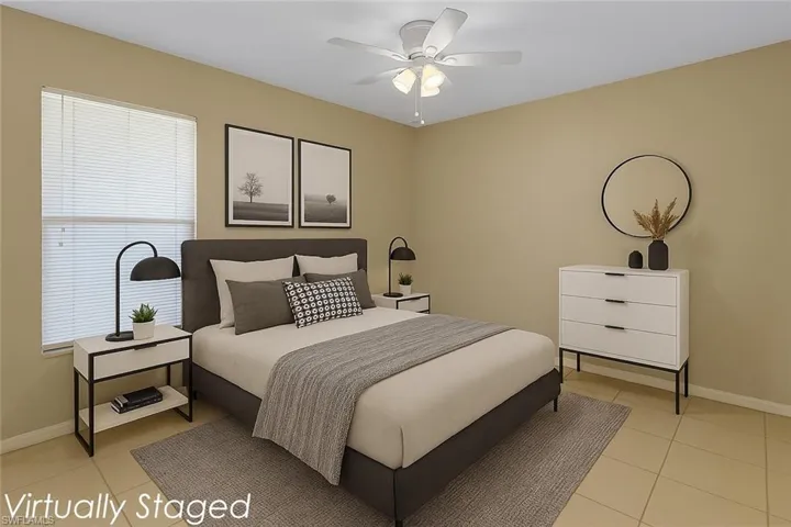 Bedroom with light tile patterned floors and a ceiling fan