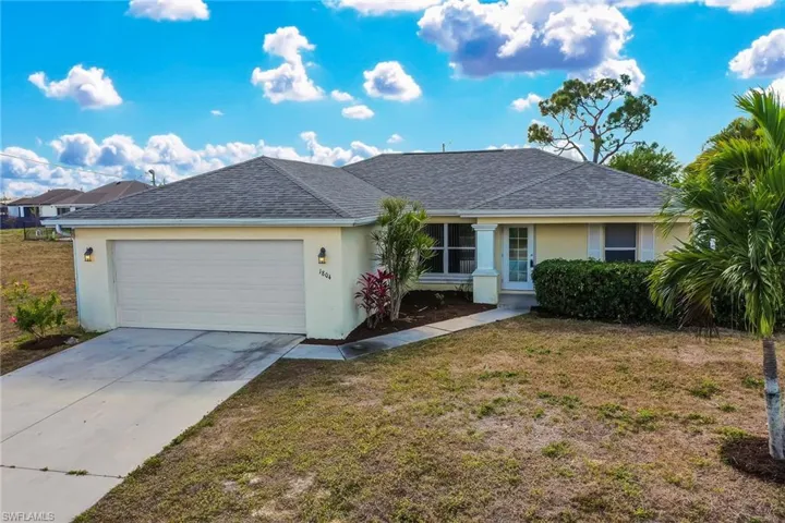 Ranch-style house with stucco siding, concrete driveway, and a front lawn