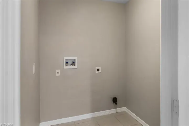 Laundry room with tile patterned floors, electric dryer hookup, and hookup for a washing machine