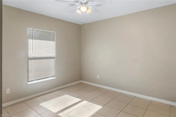 Unfurnished room featuring a ceiling fan and light tile patterned floors