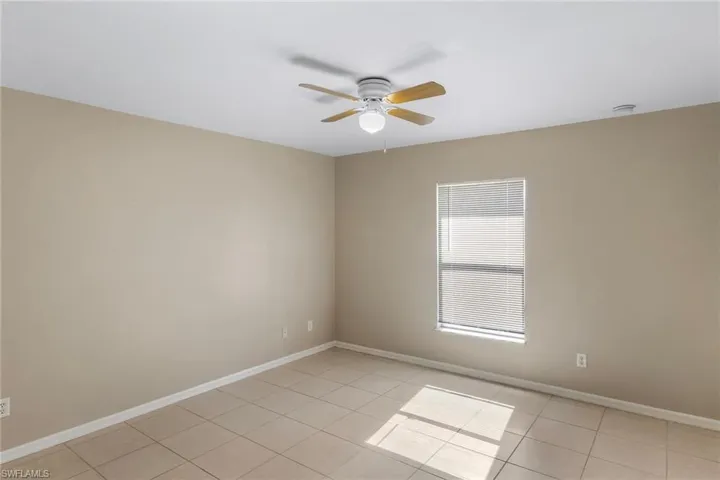 Spare room featuring ceiling fan and light tile patterned flooring