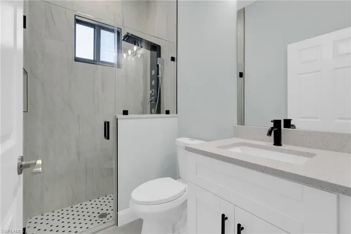 Bathroom with a marble finish shower and vanity