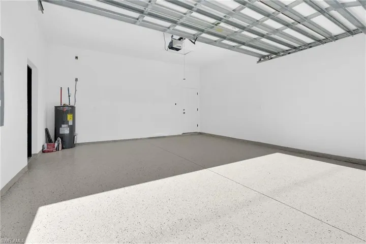 Garage with electric water heater and a garage door opener