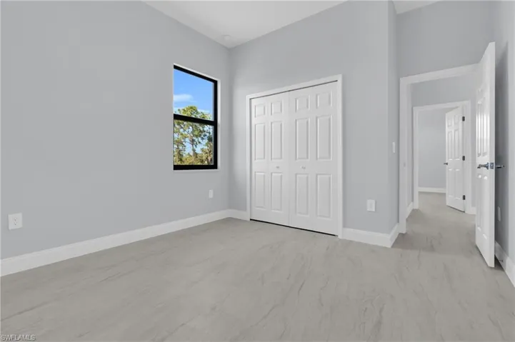 Unfurnished bedroom with a closet and light carpet
