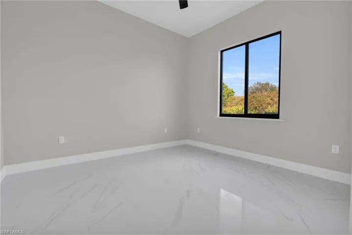 Unfurnished room with baseboards and marble look tiles