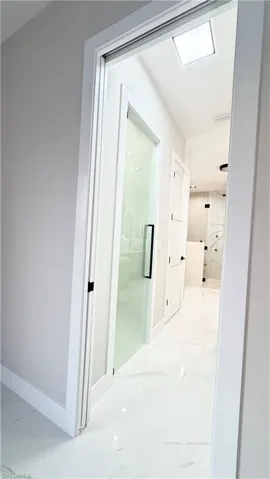 Hall featuring light marble finish flooring