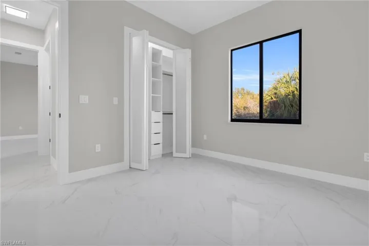 Unfurnished bedroom with light marble finish flooring and a closet