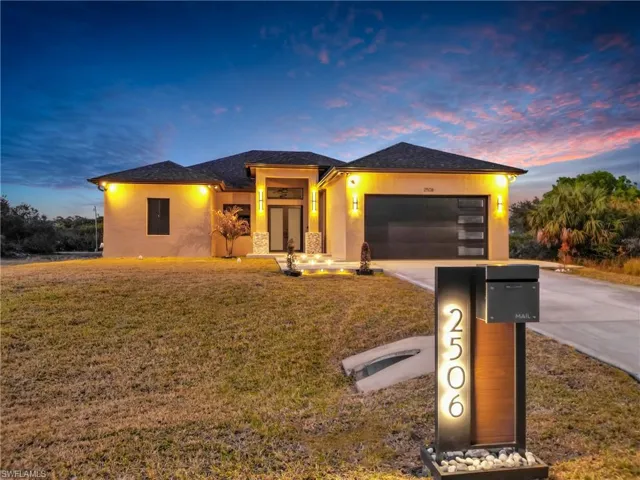 Prairie-style home featuring a yard, stucco siding, and concrete driveway