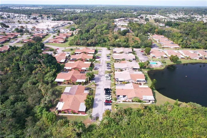 Aerial view of property and surrounding area featuring nearby suburban area and a nearby body of water