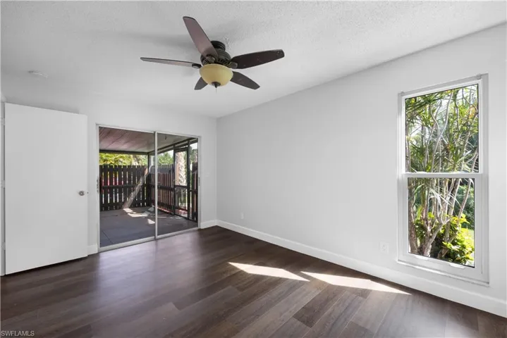 Spare room featuring dark wood-style floors, a textured ceiling, and a ceiling fan