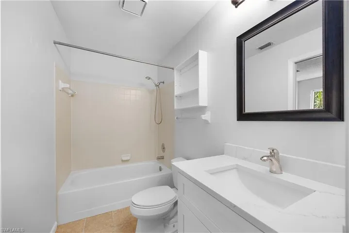 Full bathroom featuring  shower combination, vanity, and light tile patterned flooring