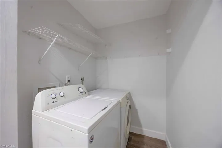 Laundry room with dark wood-type flooring and independent washer and dryer