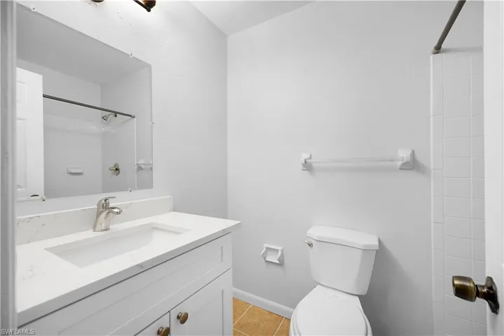 Full bath with vanity, a shower, and light tile patterned floors