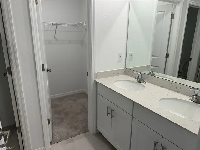 Bathroom featuring tile flooring and double sink vanity